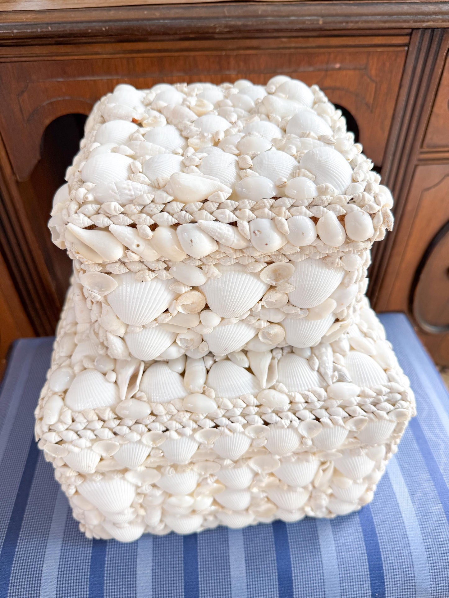 Two square boxes made entirely of white seashells. The boxes are stacked on top of each other.