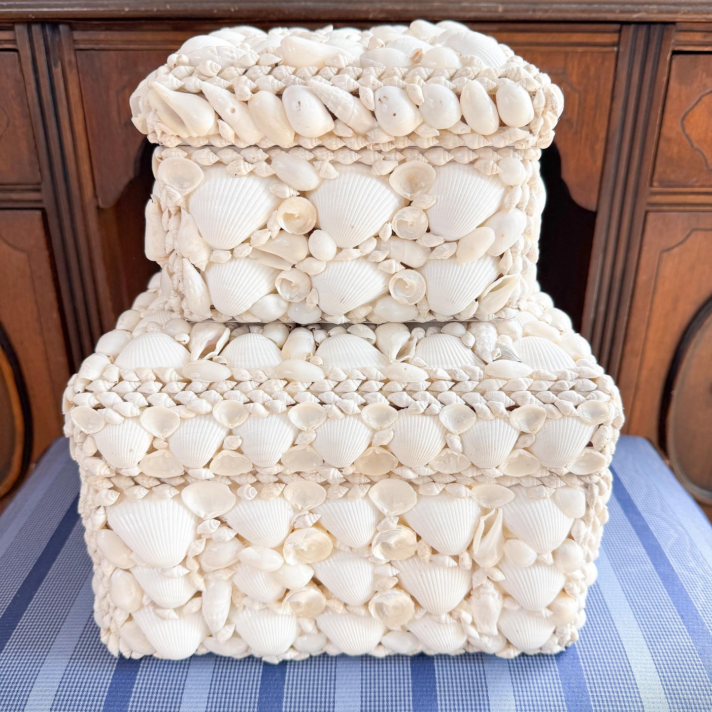 Two white square boxes made of seashells. The boxes are stacked on top of each other.